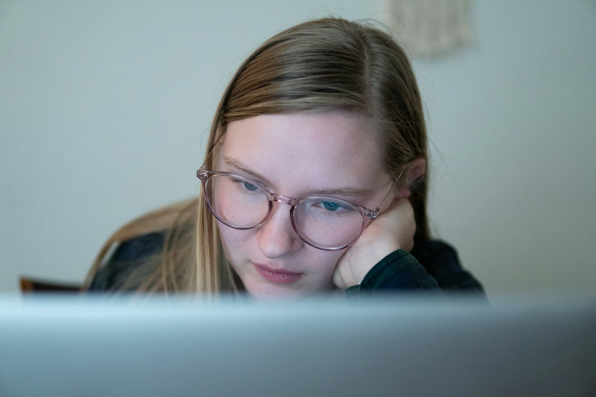 Une femme portant des lunettes travaille à l'écran